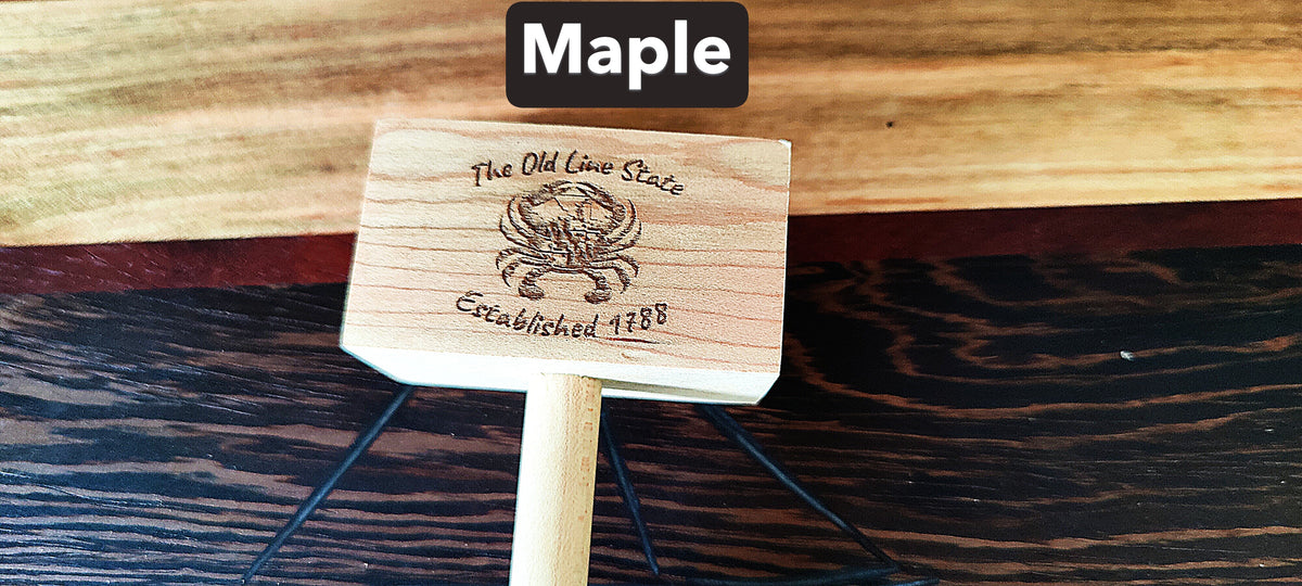 A small wooden sign or plaque on a stand, labeled 'Maple' at the top. The sign is made of light natural wood with a dark engraved emblem and text reading 'The Old Lion State' and 'Established 1788'.