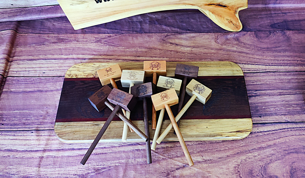 A group of small wooden mallets or game pieces with engraved tops, arranged on a dark wood board over a purple-toned wood surface.