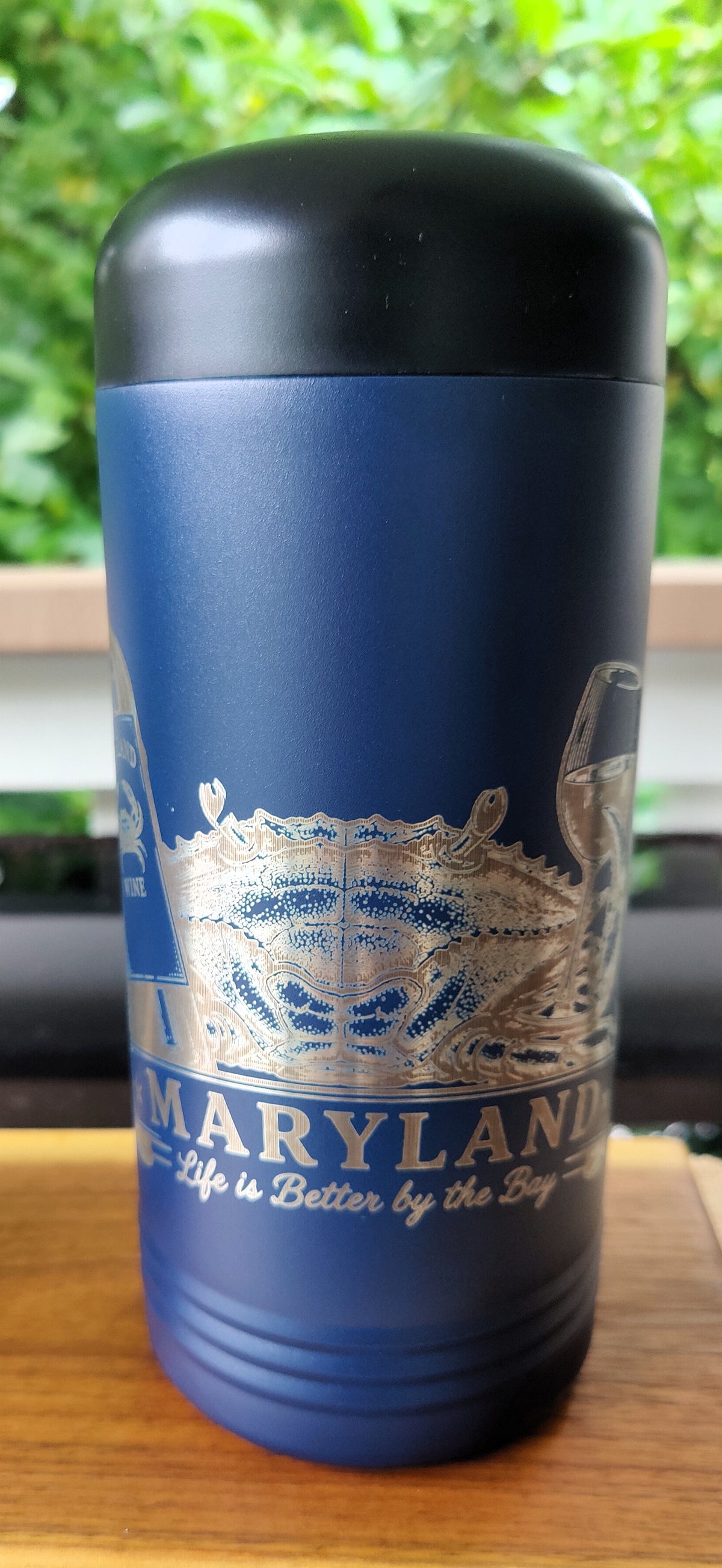 A dark blue insulated travel tumbler with a black lid, featuring a silver graphic of the Maryland state cradle and the text 'MARYLAND Life is Better by the Bay'., polar camel.