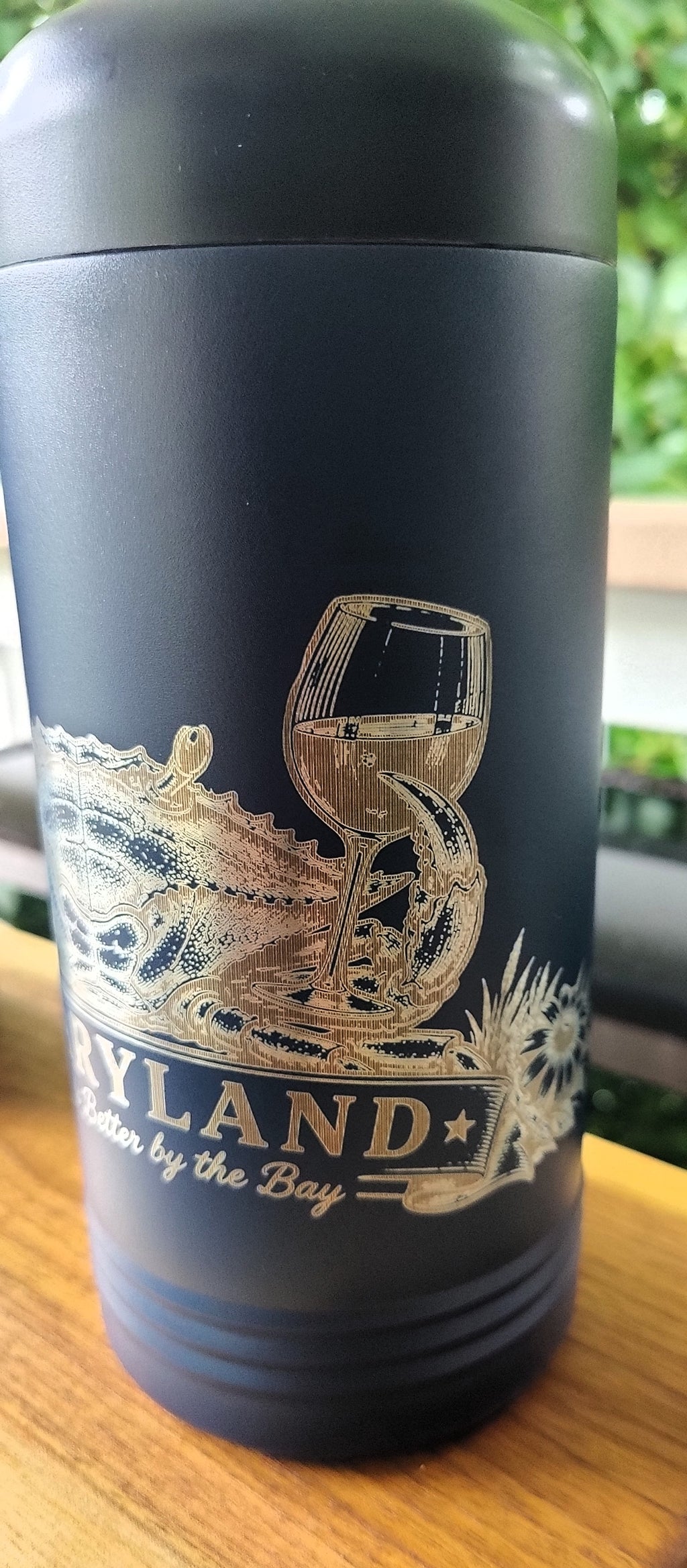 A dark navy blue insulated travel tumbler with a gold foil design featuring a wine glass and the text 'MARYLAND better by the Bay'., polar camel.